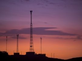 communication-towers-on-orange-purple-sky-PKHHJC9